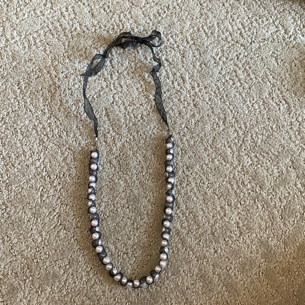 Black ribbon and Pearl necklace.
